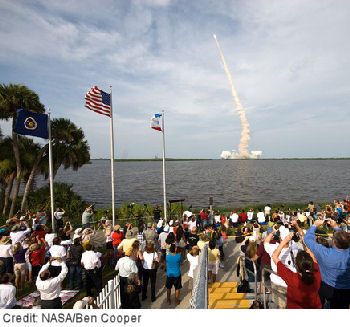 Crowds fill NASA Kennedy Space Center’s Banana River viewing site as Endeavour roars into space on July 15, 2009.