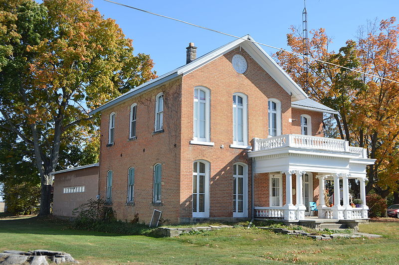 brick house with fall foliage in the background